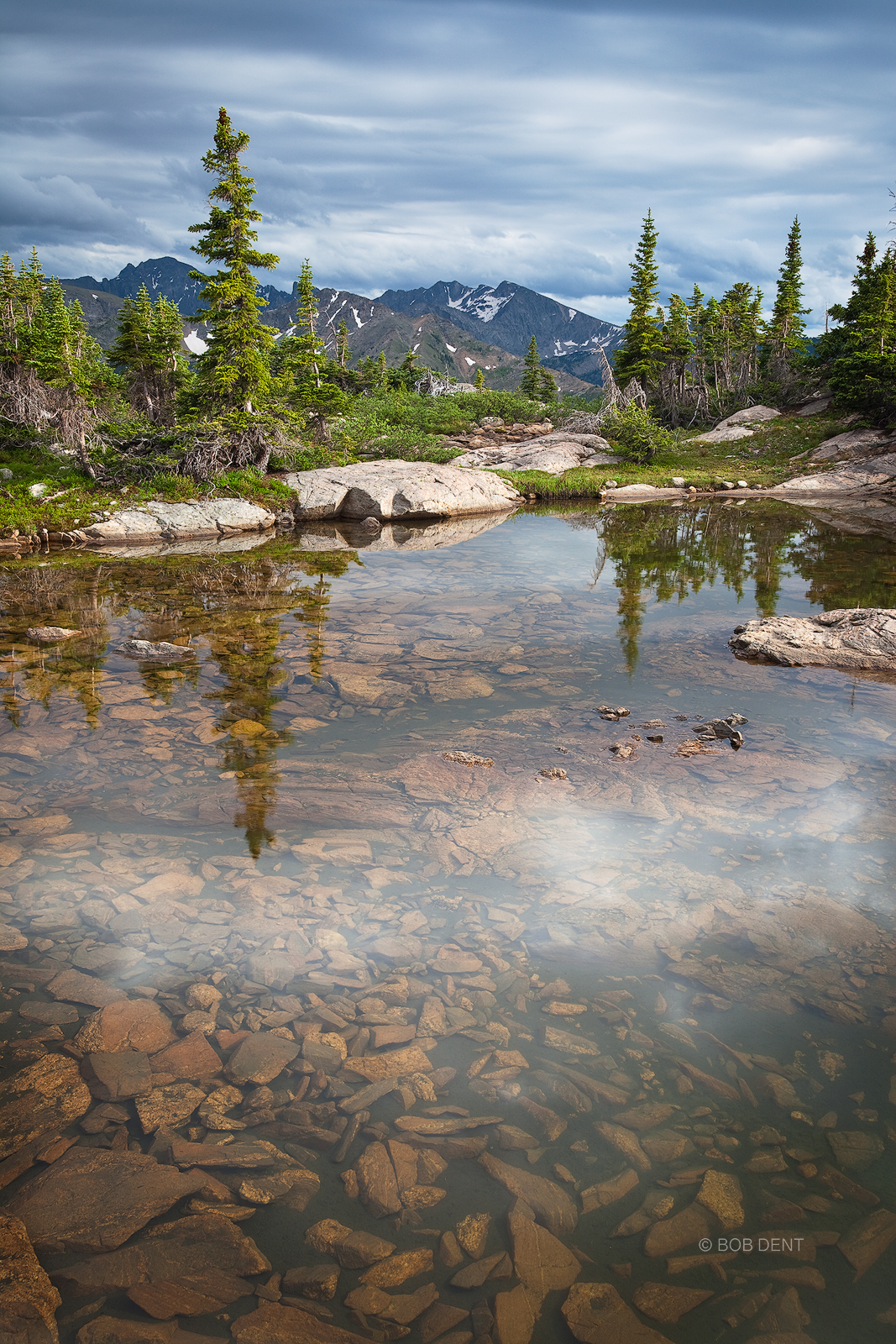 A band of clouds reflects in an alpine pool. Indian Peaks Wilderness, Colorado.