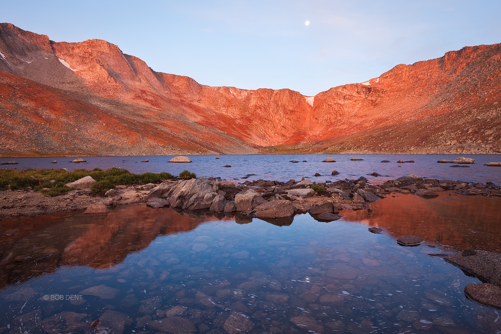 Smoke filled skies provide a warm orange glow over Summit Lake at sunrise, Mt. Evans, Colorado.